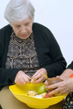Woman peeling and chopping apples after occupational therapy made it possible Woman peeling and chopping apples after occupational therapy made it possible